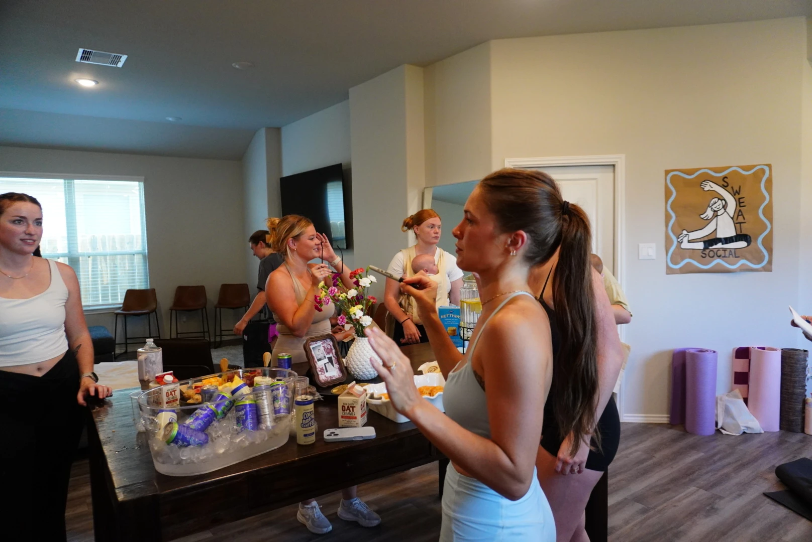 View women connecting around refreshments at Sweat Social
